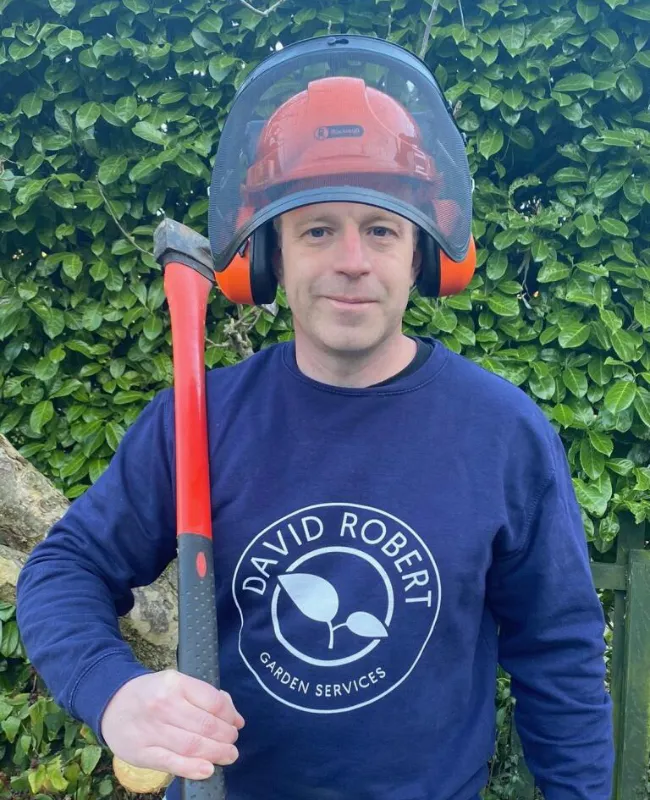 David Robert wearing a helmet and holding an axe over his shoulder